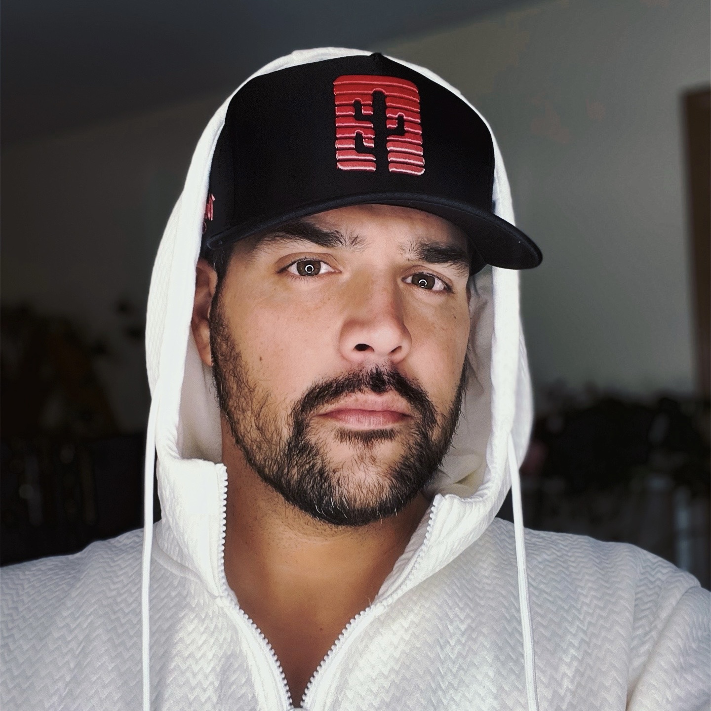 John in a white hoodie and black cap